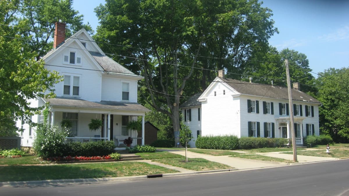 Archival photograph of wooden houses and mature trees along Columbus Street in Canal Winchester, Ohio.