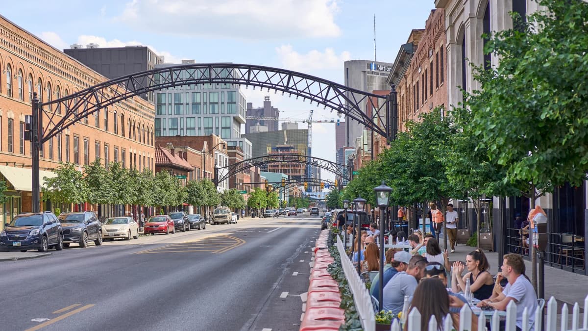 Archival photograph of High Street arches, brick buildings, pedestrians and outdoor dining in the Short North, Columbus.