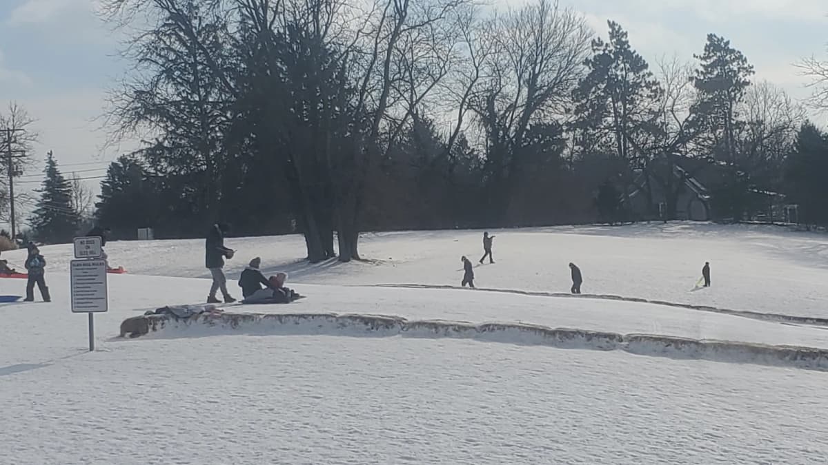 Archival photograph of people sledding on a snow-covered hill at Scioto Park in Dublin, Ohio.