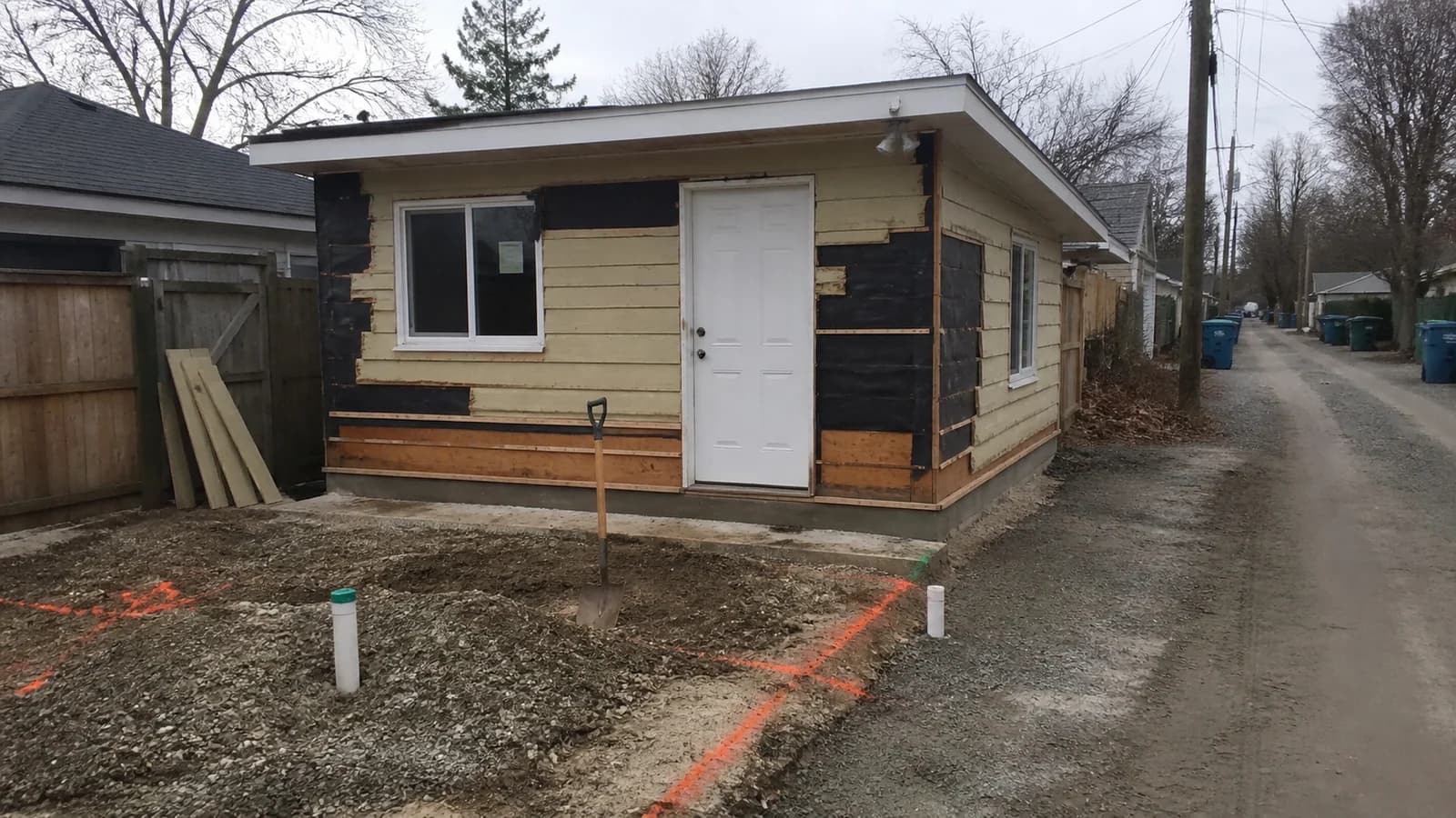 Editorial view of small detached backyard dwelling and separate main house and utility path in Columbus, Ohio.