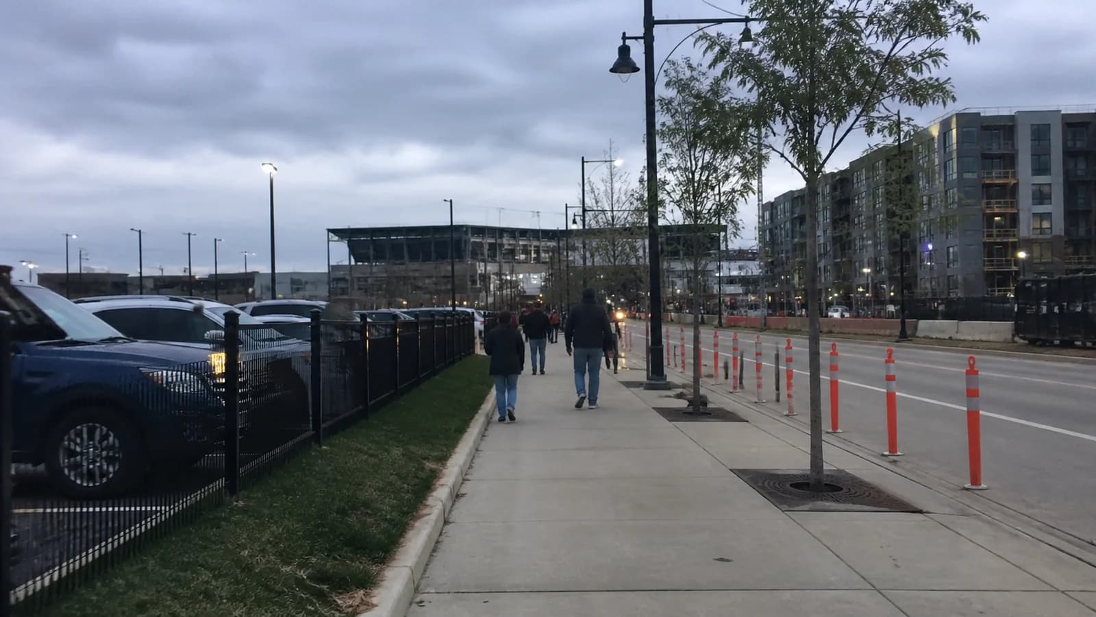 Illustrated stadium event beside a visually separate residential construction site.