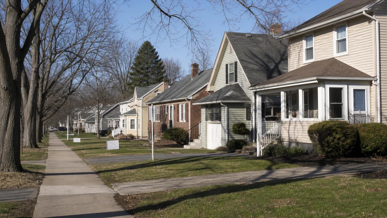 A for-sale sign in front of a residential home on a Columbus, Ohio neighborhood street in summer 2026