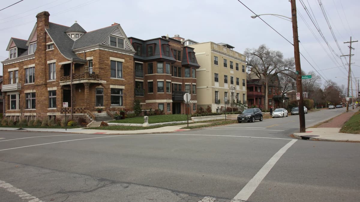 Archival photograph of older stone and brick houses near an intersection in Victorian Village, Columbus.