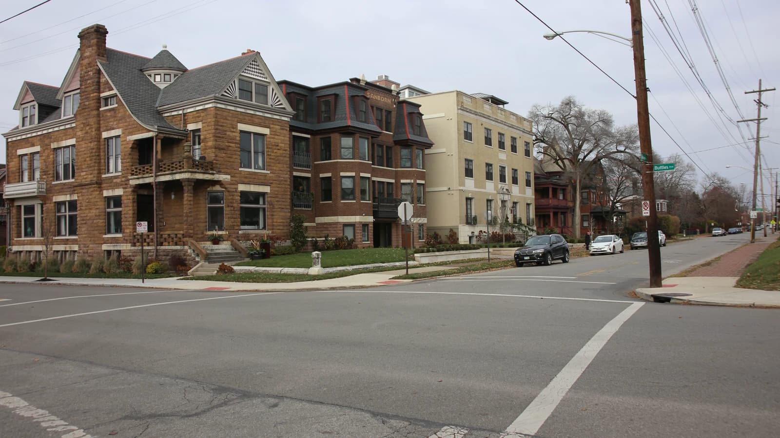 Archival photograph of older stone and brick houses near an intersection in Victorian Village, Columbus.