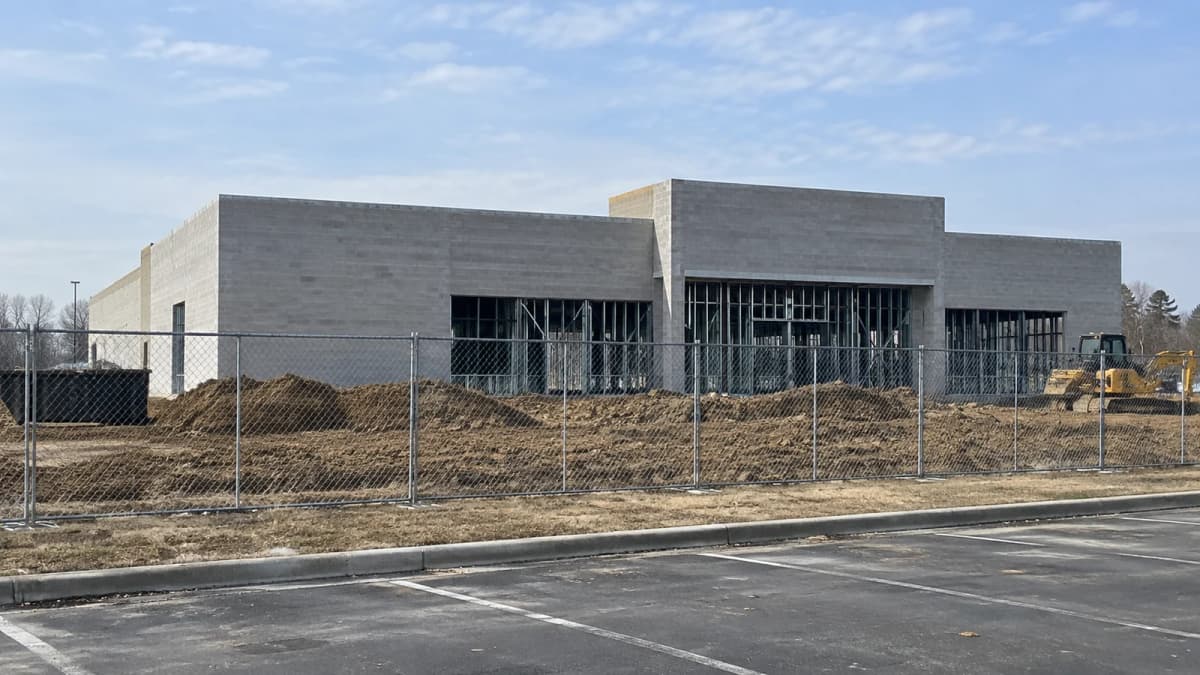 AI-generated illustration of an unfinished unbranded retail shell behind construction fencing.