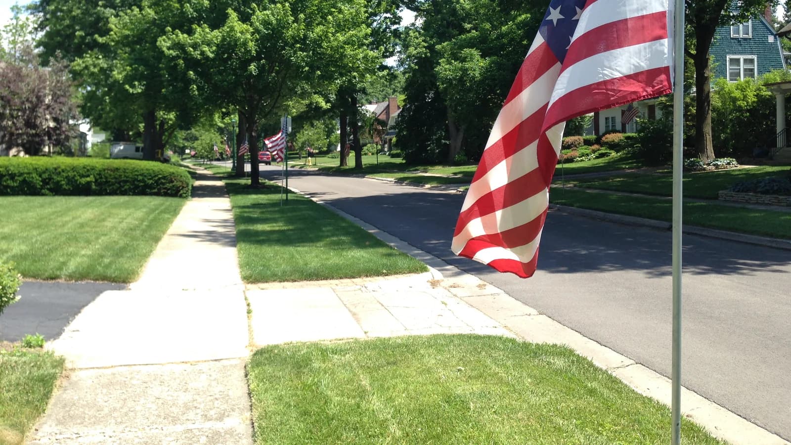 An Upper Arlington residential street near Triangle Park, with houses, trees and an American flag, photographed in June 2016.